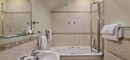 纽卡斯尔Enniskeen Country House Hotel的带浴缸、水槽和淋浴的浴室
