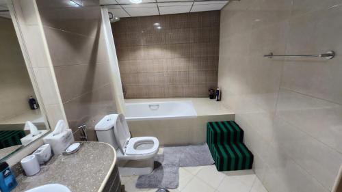 阿吉曼Ocean View Luxury Suites的带浴缸、卫生间和盥洗盆的浴室
