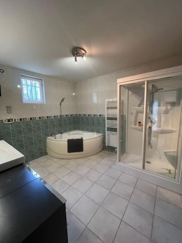 尼姆Maison de famille avec clim, piscine et parking的大型浴室设有浴缸和淋浴。