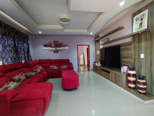 埃斯特城Ñande renda的客厅配有红色沙发和平面电视