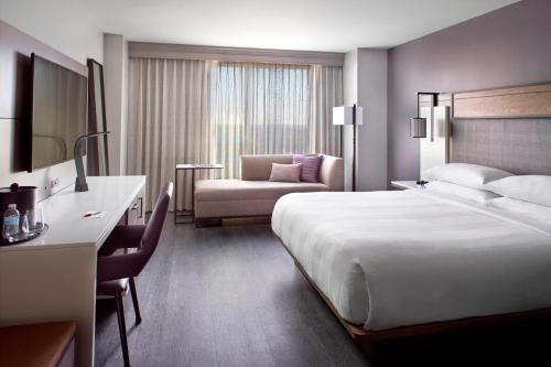 罗利罗利市中心万豪酒店的酒店客房带一张大床和一把椅子