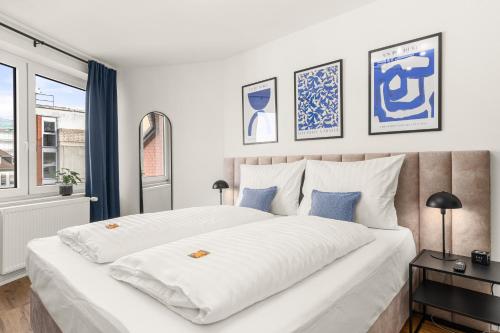 卡塞尔BLU APARTMENT -modern interior design in city centre- Nähe Uni & HBF的卧室配有带蓝色枕头的大型白色床