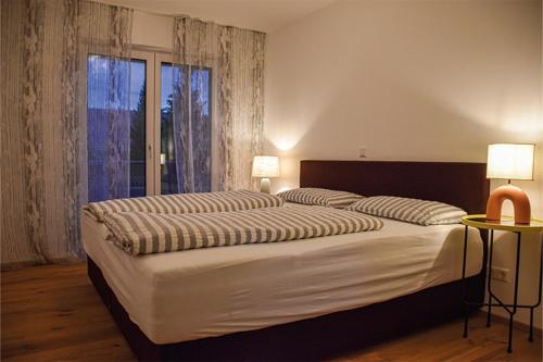 沙伊代格Ferienwohnung Bodenseeblick Nr 8的一间卧室设有一张大床和一个大窗户