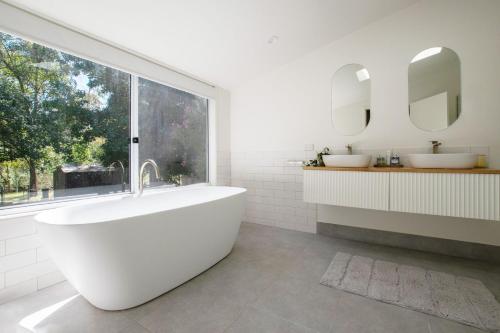 波瑞庞卡Nirvana的白色的浴室设有2个盥洗盆和1个浴缸。