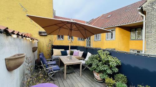 哥本哈根ApartmentInCopenhagen Apartment 1597的庭院配有遮阳伞和桌椅。