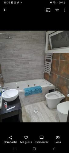 埃尔卡拉法特OLIEMI的带浴缸、盥洗盆和卫生间的浴室