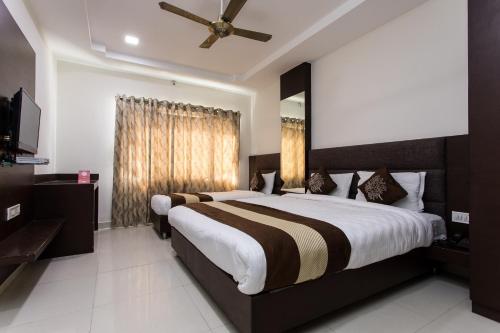 新德里Hotel Ramida Suites At Delhi Airport的一间卧室配有一张大床和吊扇