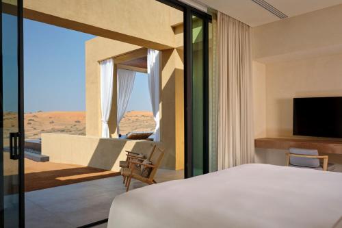 拉斯阿尔卡麦拉斯阿尔卡麦山谷沙漠丽思卡尔顿酒店的一间带沙发床的卧室,享有沙漠美景