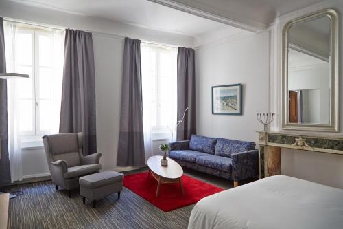 阿尔勒阿尔勒中心公寓的酒店客房配有床、沙发和桌子。
