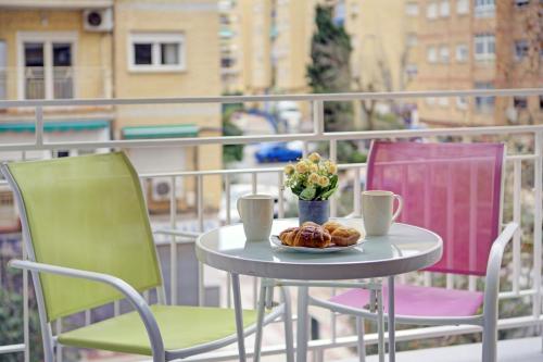 格拉纳达Apartamento en Fontiveros的阳台上的桌椅和一盘食物