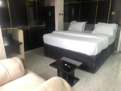 阿沙巴DAVIZZ HOTEL AND SUITES的一张大床,位于一个配有沙发和一张桌子的房间