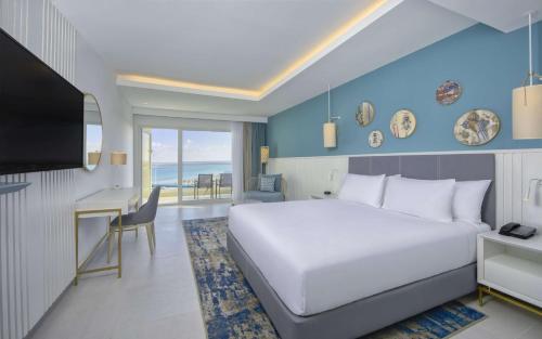 莫纳斯提尔Hilton Skanes Monastir Beach Resort的一间卧室配有一张床、一张书桌和一台电视