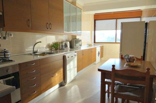 洛里什Be Local - Apartment with 2 bedrooms in Infantado in Loures的厨房配有水槽、冰箱和桌子