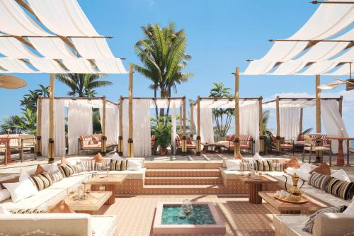 ḨanakNujuma, a Ritz-Carlton Reserve的度假村的庭院配有白色的沙发和桌子