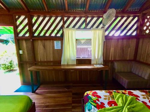 卡维塔Alouatta Hanging Bridges Adventure and Lodge的小房间设有长凳和窗户