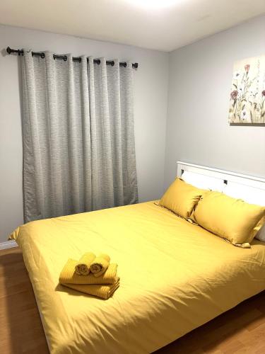 耶洛奈夫Spacious Downtown 3BR Home, 4bds的一间卧室配有黄色的床和2条毛巾