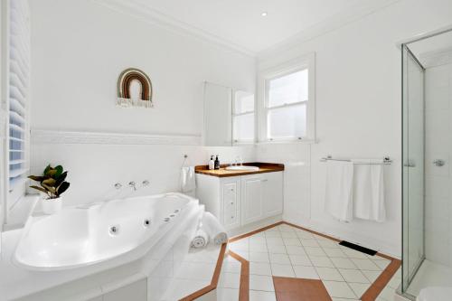墨尔本Essendon Allambee Haven 4BR的白色的浴室设有浴缸和水槽。