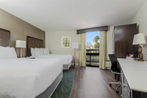 圣地亚哥圣地亚哥市中心小意大利福朋喜来登酒店 的酒店客房设有两张床和一个阳台。