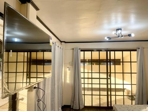 马斯巴特Maria Kulafu Studio Deluxe的一间设有窗户和窗帘的门的房间