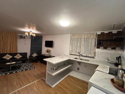 卡哈马卡Mini departamentos Miramar的厨房以及带水槽和沙发的客厅。