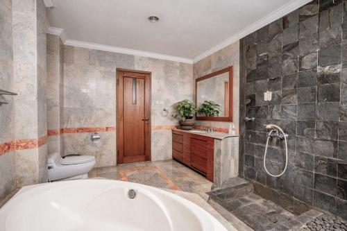 万隆Pasteur Beautiful Luxury Home的带浴缸和卫生间的浴室。