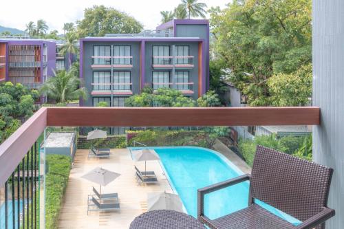 芭东海滩Holiday Inn Express Phuket Patong Beach Central, an IHG Hotel的公寓的阳台设有游泳池和椅子