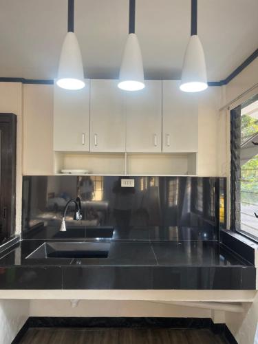 马斯巴特Maria Kulafu Studio Deluxe的厨房配有黑色台面和水槽