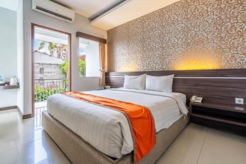 塞米亚克Casa Dasa Legian的一间卧室配有一张带橙色毯子的大床