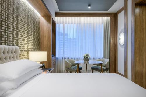 马德里库斯科万豪AC酒店的卧室配有白色的床、桌子和窗户。