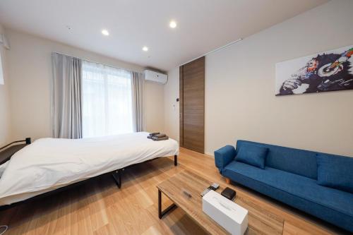 东京La Terrasse Higashikomagata - Vacation STAY 17380v的一间卧室配有一张床和一张蓝色的沙发