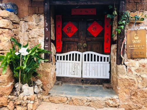 丽江Lijiang Jayden Lodge臣安山居民宿 - Namaste的石头建筑的入口,带有木门