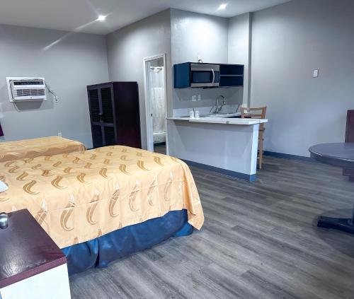 埃尔卡洪El Cajon Inn & Suites的客房设有床、厨房和水槽。