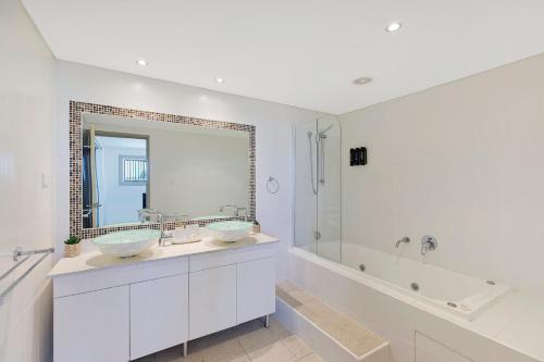 安特兰斯Ocean Parade - Penthouse - Ocean Views的浴室设有2个水槽、浴缸和镜子