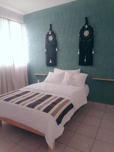 图卢姆La casa gris的一间卧室设有一张大床和绿色的墙壁