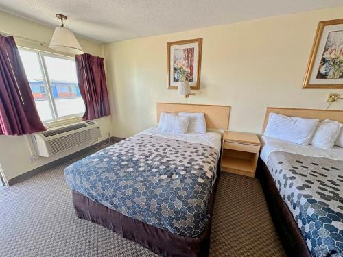 BoardmanRodeway Inn Boardman - Hermiston的酒店客房设有两张床和窗户。