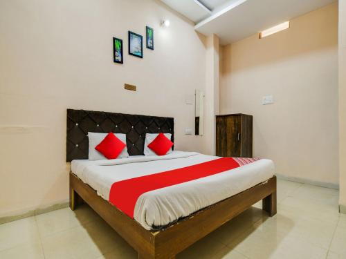 印多尔OYO Hotel Airport View的一间卧室配有一张带红色枕头的大床