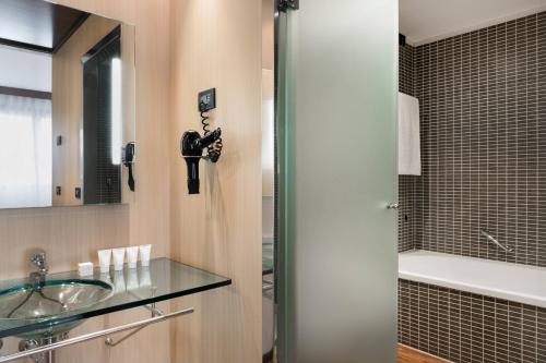 博洛尼亚博洛尼亚万豪AC酒店的一间带玻璃水槽和淋浴的浴室