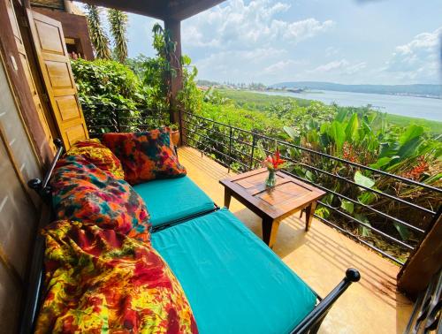 金贾Home On The Nile Ernest Hemingway Suite的阳台设有沙发和桌子,享有美景。
