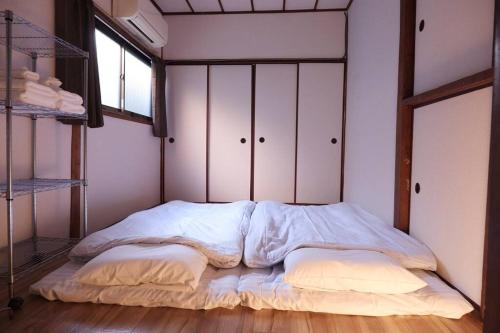 大阪TSUBAME 101 staying private home的窗户客房内一张未铺床