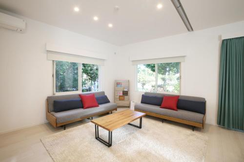 石垣岛アイニクル -Create Future Community-的客厅配有两张沙发和一张咖啡桌