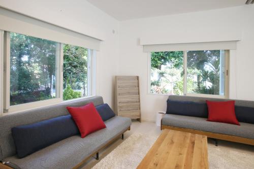 石垣岛アイニクル -Create Future Community-的客厅设有2张沙发和2扇窗户