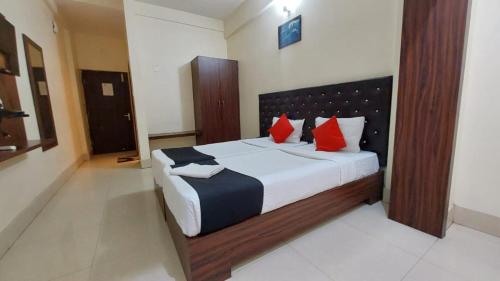布巴内什瓦尔Hotel Tripletree Bhubaneswar的一间卧室配有一张带红色枕头的大床