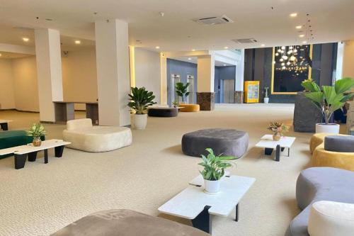 胡志明市The Arrivals Hotel的一个大大堂配有沙发、桌子和植物