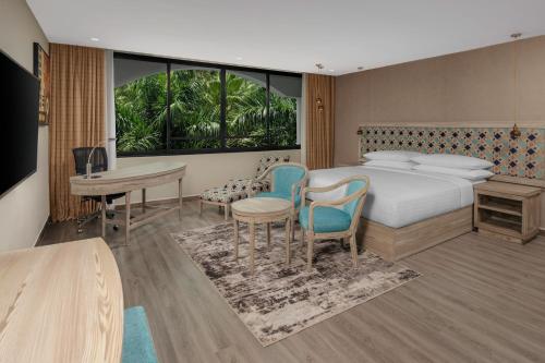 达累斯萨拉姆Delta Hotels by Marriott Dar es Salaam的酒店客房带一张床、一张桌子和椅子