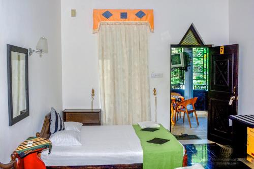 安帕赖Terrel Residencies Gal Oya的一间卧室设有一张床、一个窗口和一张桌子