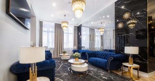 乔左维尔考普尔斯基Hotel Pavco的大堂设有蓝色的长沙发、桌子和吊灯。