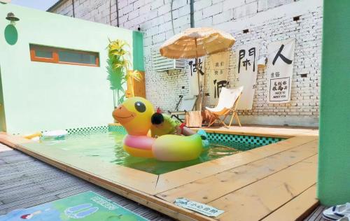 怀柔长城脚下relax家民宿的游泳池里的一只小橡皮鸭,带雨伞