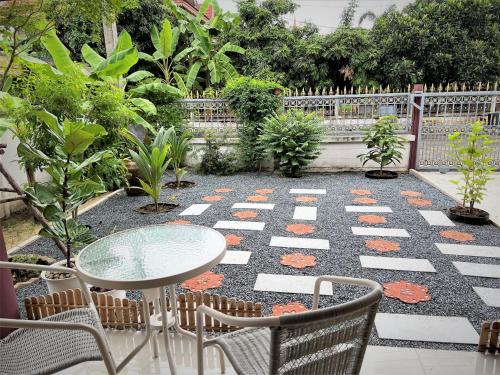 Ban Lam Riห้องพักสบาย เป็นส่วนตัวในบ้านเรือนไทยที่ตอบโจทย์ความต้องการ的庭院配有桌椅和植物