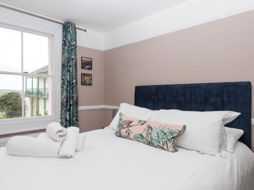廷茅斯Rose Cottage的卧室配有白色的床和窗户