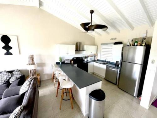 辛普森湾New* Tropical Modern Townhouse in SXM的厨房以及带沙发和冰箱的客厅。